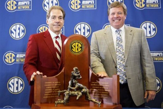 Alabama head coach Nick Saban, left, and Florida head coach Jim McElwain pose with the trophy during a press conference held ahead of Saturday's Southeastern Conference championship NCAA college football game, Friday, Dec. 4, 2015, in Atlanta. (AP Photo/David Goldman)