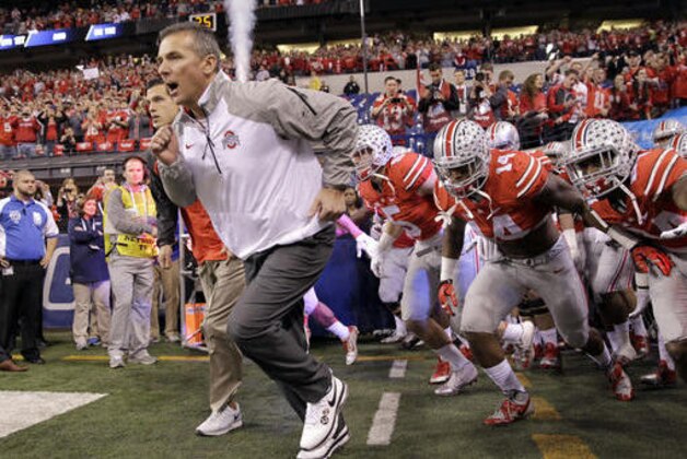 FILE - In this Dec. 6, 2014 file photo, Ohio State head coach Urban Meyer runs onto the field with his team at the start of the Big Ten Conference championship NCAA college football game against Wisconsin in Indianapolis. If No. 1 Alabama and No. 2 Ohio State are going to lose this season, this would be an excellent week to do so. The Crimson Tide taken on No. 9 Tennessee, while the Buckeyes take on No. 8 Wisconsin. (AP Photo/Darron Cummings, File)