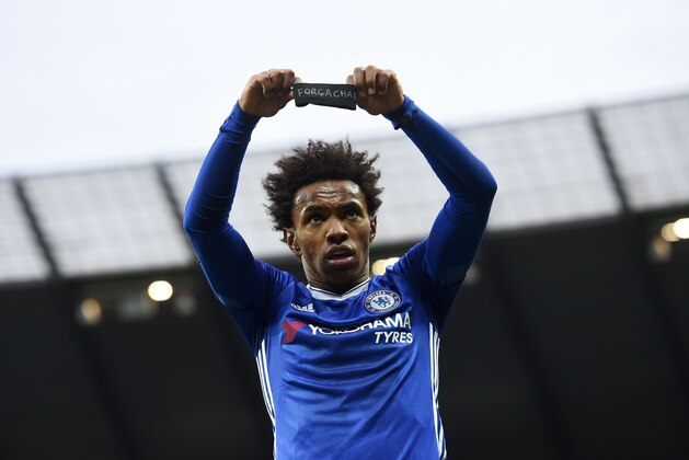 Chelsea's Brazilian midfielder Willian holds up his black armband as he celebrates scoring his team's second goal during the English Premier League football match between Manchester City and Chelsea at the Etihad Stadium in Manchester, north west England, on December 3, 2016. / AFP / Paul ELLIS / RESTRICTED TO EDITORIAL USE. No use with unauthorized audio, video, data, fixture lists, club/league logos or 'live' services. Online in-match use limited to 75 images, no video emulation. No use in betting, games or single club/league/player publications.  /         (Photo credit should read PAUL ELLIS/AFP/Getty Images)