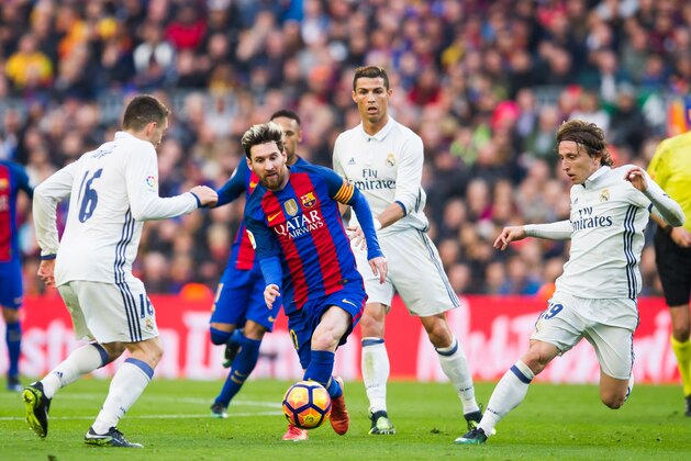 BARCELONA, SPAIN - DECEMBER 03:  Lionel Messi (C) of FC Barcelona conducts the ball between Mateo Kovacic (L), Cristiano Ronaldo (2nd R) and Luka Modric (R) of Real Madrid CF during the La Liga match between FC Barcelona and Real Madrid CF at Camp Nou stadium on December 3, 2016 in Barcelona, Spain.  (Photo by Alex Caparros/Getty Images)