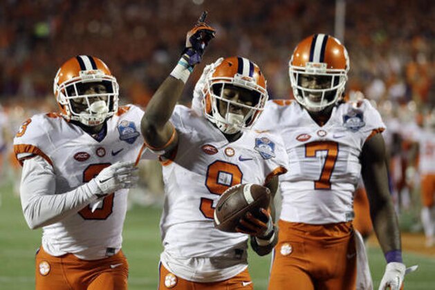Clemson wide receivers Artavis Scott (3) and Mike Williams (7), congratulate running back Wayne Gallman (9) after Gallman scored a touchdown during the second half of the Atlantic Coast Conference championship NCAA college football game against Virginia Tech , Saturday, Dec. 3, 2016, in Orlando, Fla. (AP Photo/Chris O'Meara)