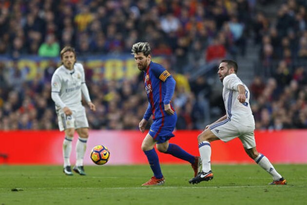 Barcelona's Lionel Messi, centre, vies for the ball with Daniel Carvajal, right, during of the Spanish La Liga soccer match between FC Barcelona and Real Madrid at the Camp Nou in Barcelona, Spain, Saturday, Dec. 3, 2016. The match ended in a 1-1 draw. (AP Photo/Francisco Seco)