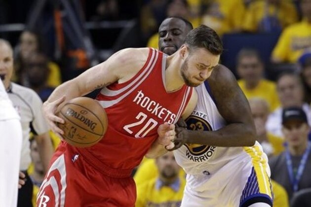 Houston Rockets' Donatas Motiejunas (20) dribbles around Golden State Warriors' Draymond Green during the second half in Game 1 of a first-round NBA basketball playoff series Saturday, April 16, 2016, in Oakland, Calif. Golden State won 104-78. (AP Photo/Marcio Jose Sanchez)