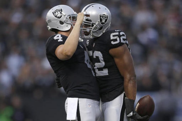 Oakland Raiders quarterback Derek Carr (4) celebrates with defensive end Khalil Mack (52) during the second half of an NFL football game against the Buffalo Bills in Oakland, Calif., Sunday, Dec. 4, 2016. The Raiders won 38-24. (AP Photo/D. Ross Cameron)