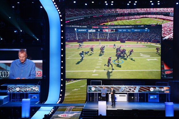 NFL Hall of Fame quarterback Joe Montana (L) plays the new EA Sports Madden 13 game as head of EA Sports Andrew Wilson (R) looks on after announcing all-new Kinect voice functionality for the new EA Sports games at the Microsoft Xbox E3 2012 media briefing in Los Angeles on June 4, 2012. The Electronic Entertainment Expo (E3), the video game industry's biggest event, runs from June 5-7.    AFP PHOTO/ROBYN BECK        (Photo credit should read ROBYN BECK/AFP/GettyImages)