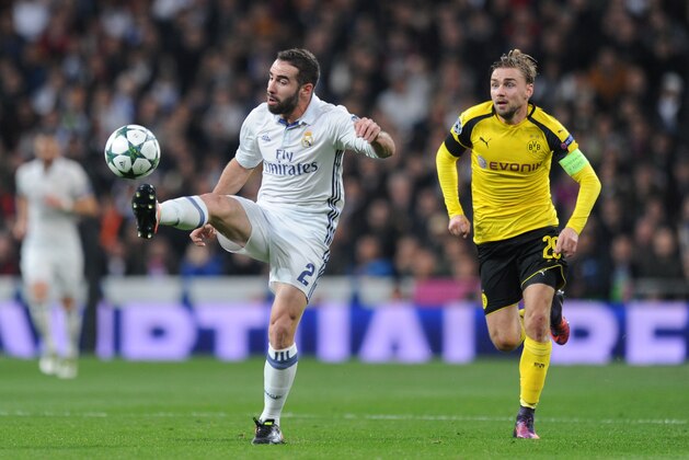 MADRID, SPAIN - DECEMBER 07: Daniel Carvajal of Real Madrid (L) controls the ball while Marcel Schmelzer of Borussia Dortmund (R) closes him down during the UEFA Champions League Group F match between Real Madrid CF and Borussia Dortmund at the Bernabeu on December 7, 2016 in Madrid, Spain.  (Photo by Denis Doyle/Getty Images)