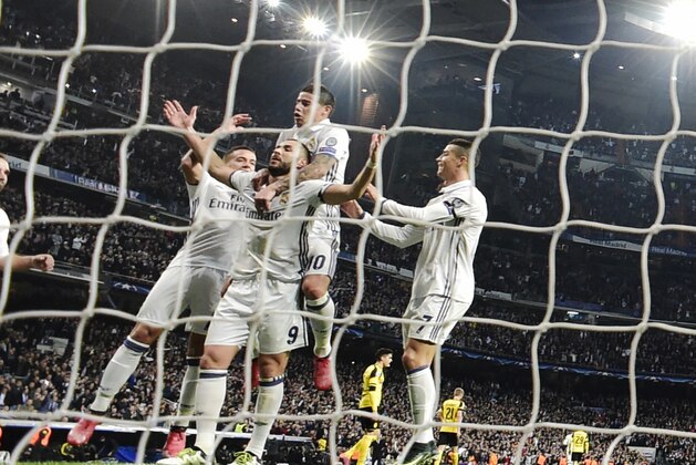 Real Madrid players celebrate Real Madrid's French forward Karim Benzema's goal during the UEFA Champions League football match Real Madrid CF vs Borussia Dortmund at the Santiago Bernabeu stadium in Madrid on December 7, 2016. / AFP / JAVIER SORIANO        (Photo credit should read JAVIER SORIANO/AFP/Getty Images)