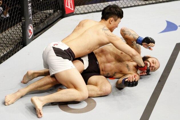 SEOUL, SOUTH KOREA - NOVEMBER 28: Doo Ho Choi of South Korea punches Sam Sicilia of the United States of America in their  featherweight bout during the UFC Fight Night at the Olympic Park Gymnastics Arena on November 28, 2015 in Seoul, South Korea. (Photo by Mitch Viquez/Zuffa LLC/Zuffa LLC via Getty Images)