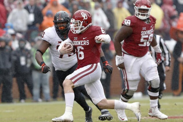 FILE - In a Saturday, Dec. 3, 2016 file photo, Oklahoma quarterback Baker Mayfield (6) runs in front of Oklahoma State defensive tackle Darrion Daniels (79) during the second half of an NCAA college football game in Norman, Okla. Mayfield made his name as an underdog with something to prove. Now, he's bound for New York as a Heisman finalist. (AP Photo/Alonzo Adams, File)