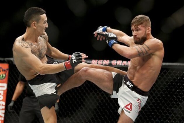 Max Holloway, left, fights Jeremy Stephens during a featherweight mixed martial arts bout at UFC 194, Saturday, Dec. 12, 2015, in Las Vegas. (AP Photo/John Locher)