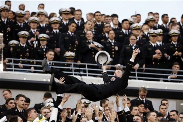 A Navy Midshipman is tossed in the air as Navy fans celebrate a touchdown during an NCAA college football game against Army and Saturday, Dec. 12, 2015, in Philadelphia. (AP Photo/Matt Slocum)