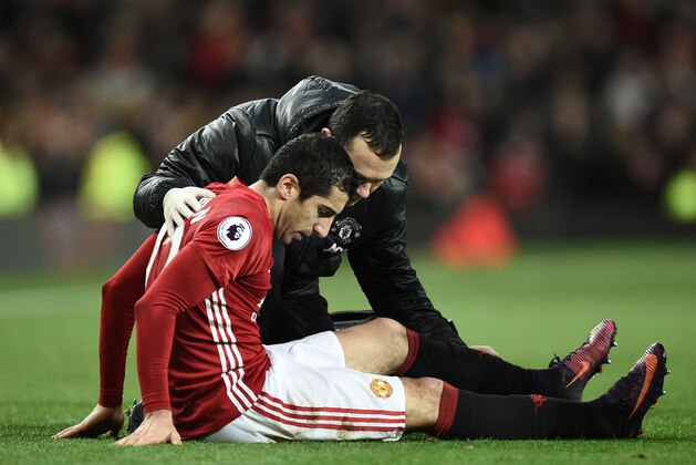 Manchester United's Armenian midfielder Henrikh Mkhitaryan receives attention after picking up an injury during the English Premier League football match between Manchester United and Tottenham Hotspur at Old Trafford in Manchester, north west England, on December 11, 2016. / AFP / OLI SCARFF / RESTRICTED TO EDITORIAL USE. No use with unauthorized audio, video, data, fixture lists, club/league logos or 'live' services. Online in-match use limited to 75 images, no video emulation. No use in betting, games or single club/league/player publications.  /         (Photo credit should read OLI SCARFF/AFP/Getty Images)