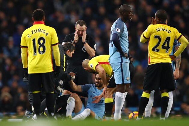 MANCHESTER, ENGLAND - DECEMBER 14: Ilkay Gundogan (C) of Manchester City receives medical treatment before being substituted due to an injury during the Premier League match between Manchester City and Watford at Etihad Stadium on December 14, 2016 in Manchester, England.  (Photo by Clive Brunskill/Getty Images)