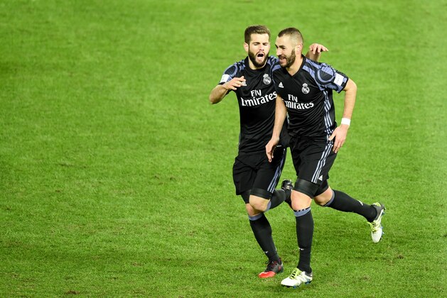 Real Madrid's forward Karim Benzema (R) is congratulated by teammate Nacho Fernandez (L) after scoring a goal during the Club World Cup semi-final football match between Club America of Mexico and Real Madrid of Spain at Yokohama International stadium in Yokohama on December 15, 2016. / AFP / TORU YAMANAKA        (Photo credit should read TORU YAMANAKA/AFP/Getty Images)