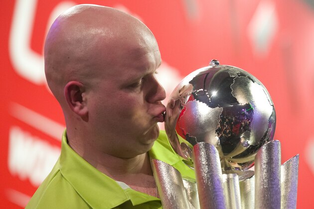Netherlands Michael van Gerwen celebrates with the Sid Waddell trophy after defeating Britains Peter Wright in the PDC World Championship darts final at Alexandra Palace in north London on January 1, 2014. AFP PHOTO / JUSTIN TALLIS        (Photo credit should read JUSTIN TALLIS/AFP/Getty Images)