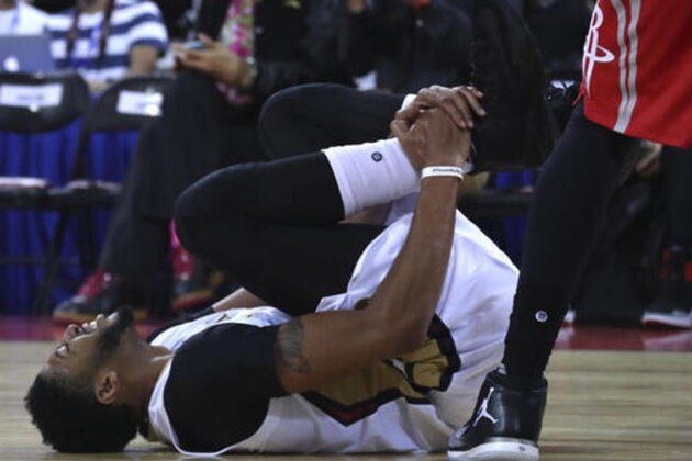 Anthony Davis of the New Orleans Pelicans reacts in pain as he injures his right ankle during a preseasons match against Houston Rockets in Beijing, China, Wednesday, Oct. 12, 2016. Davis fell to the court early in the first quarter of Wednesday's game in Beijing, the last of the NBA's two exhibitions in China. He re-entered the game briefly, but soon walked to the locker room. (AP Photo/Ng Han Guan)