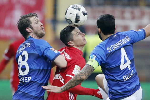 Darmstadt's Jerome Gondorf, left, and Darmstadt's Aytac Sulu, right, frame  Bayern's Robert Lewandowski as they challenge for the ball  during a German first division Bundesliga soccer match between Darmstadt 98 and Bayern Munich in Darmstadt, Germany, Sunday, Dec. 18, 2016.(AP Photo/Michael Probst)