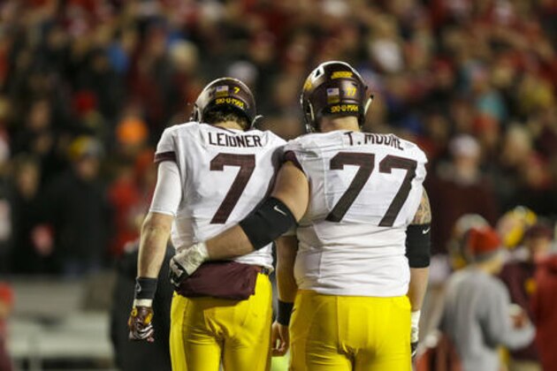 Minnesota quarterback Mitch Leidner (7) and Tyler Moore walk back to the sidelines after Leidner threw an interception during the second half of an NCAA college football game against Wisconsin, Saturday, Nov. 26, 2016, in Madison, Wis. Wisconsin won 31-17. (AP Photo/Andy Manis)
