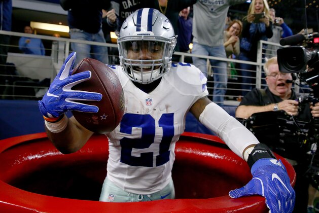 ARLINGTON, TX - DECEMBER 18:  Ezekiel Elliott #21 of the Dallas Cowboys celebrates after scoring a touchdown by jumping into a Salvation Army red kettle during the second quarter against the Tampa Bay Buccaneers at AT&T Stadium on December 18, 2016 in Arlington, Texas.  (Photo by Tom Pennington/Getty Images)