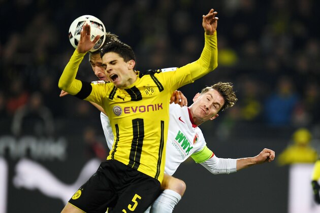 Augsburg's Dutch defender Paul Verhaegh and Dortmund's Spanish defender Marc Bartra vie for the ball during the German First division Bundesliga football match between Borussia Dortmund and FC Augsburg, in Dortmund, western Germany, on December 20, 2016.  / AFP / PATRIK STOLLARZ / RESTRICTIONS: DURING MATCH TIME: DFL RULES TO LIMIT THE ONLINE USAGE TO 15 PICTURES PER MATCH AND FORBID IMAGE SEQUENCES TO SIMULATE VIDEO. == RESTRICTED TO EDITORIAL USE == FOR FURTHER QUERIES PLEASE CONTACT DFL DIRECTLY AT + 49 69 650050
        (Photo credit should read PATRIK STOLLARZ/AFP/Getty Images)