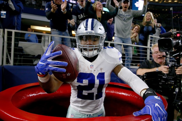 ARLINGTON, TX - DECEMBER 18:  Ezekiel Elliott #21 of the Dallas Cowboys celebrates after scoring a touchdown by jumping into a Salvation Army red kettle during the second quarter against the Tampa Bay Buccaneers at AT&T Stadium on December 18, 2016 in Arlington, Texas.  (Photo by Tom Pennington/Getty Images)