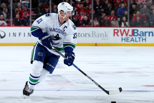 NEWARK, NJ - DECEMBER 06:  Henrik Sedin #33 of the Vancouver Canucks takes the puck in the third period against the New Jersey Devils on December 6, 2016 at Prudential Center in Newark, New Jersey.  (Photo by Elsa/Getty Images)