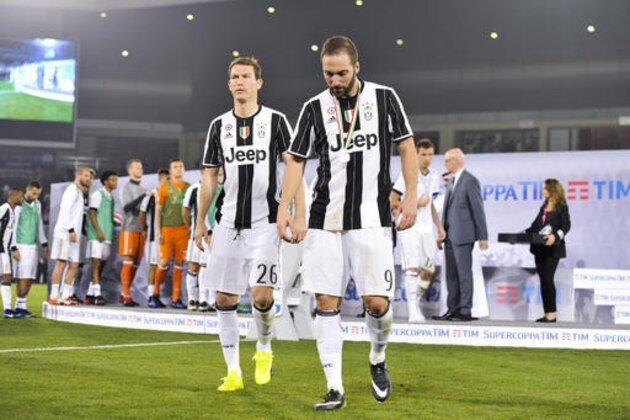 Juventus' Stephan Lichtsteiner, left, and Gonzalo Higuain walk off the pitch at the end of the Italian Super Cup soccer match between Juventus and AC Milan, at the Al Sadd Sports Club in Doha, Qatar, Friday, Dec. 23, 2016. AC Milan won 5-4 following a shootout. (AP Photo/Alexandra Panagiotidou)