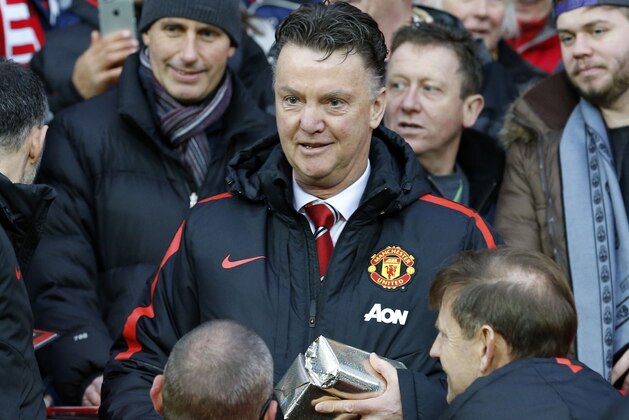 Manchester United's Dutch manager Louis van Gaal hands out Christmas presents to fans before during the English Premier League football match between Manchester United and Newcastle United at Old Trafford in Manchester, north west England, on December 26, 2014.  AFP PHOTO / LINDSEY PARNABY

RESTRICTED TO EDITORIAL USE. No use with unauthorized audio, video, data, fixture lists, club/league logos or live services. Online in-match use limited to 45 images, no video emulation. No use in betting, games or single club/league/player publications.        (Photo credit should read LINDSEY PARNABY/AFP/Getty Images)