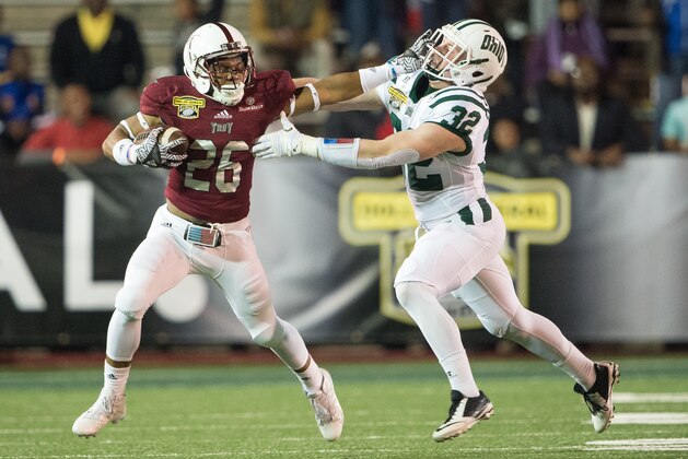 MOBILE, AL - DECEMBER 23: Running back B.J. Smith #26 of the Troy Trojans stiff arms linebacker Quentin Poling #32 of the Ohio Bobcats on December 23, 2016 in Mobile, Alabama. (Photo by Michael Chang/Getty Images)