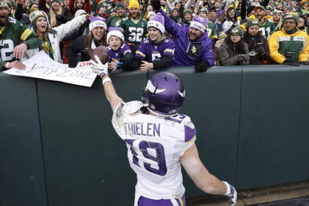 Minnesota Vikings' Adam Thielen hands a fan the ball after catching a touchdown pass during the second half of an NFL football game Saturday, Dec. 24, 2016, in Green Bay, Wis. The Packers won 38-25. (AP Photo/Jeffrey Phelps)