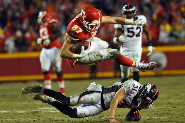 KANSAS CITY, MO - DECEMBER 25:  Tight end Travis Kelce #87 of the Kansas City Chiefs leaps over free safety Justin Simmons #31 of the Denver Broncos during the game at Arrowhead Stadium on December 25, 2016 in Kansas City, Missouri.  (Photo by Jason Hanna/Getty Images)