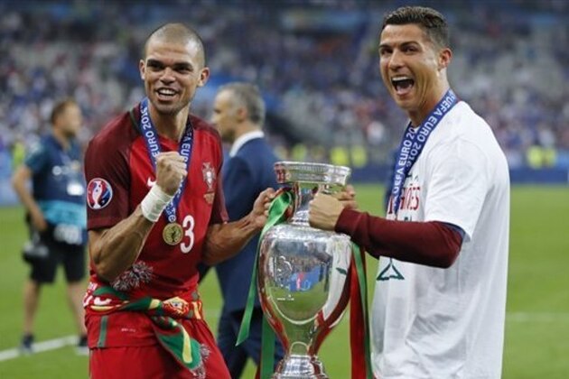Portugal's Cristiano Ronaldo, right, and Pepe celebrate with the trophy at the end of the Euro 2016 final soccer match between Portugal and France at the Stade de France in Saint-Denis, north of Paris, Sunday, July 10, 2016. Portugal won 1-0. (AP Photo/Frank Augstein)