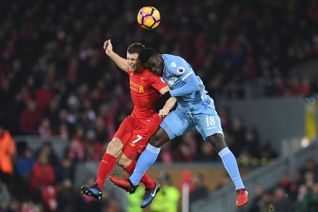 TOPSHOT - Stoke City's Senegalese striker Mame Biram Diouf (R) and Liverpool's English midfielder James Milner (L) contest a high ball during the English Premier League football match between Liverpool and Stoke City at Anfield in Liverpool, north west England on December 27, 2016. / AFP / Paul ELLIS / RESTRICTED TO EDITORIAL USE. No use with unauthorized audio, video, data, fixture lists, club/league logos or 'live' services. Online in-match use limited to 75 images, no video emulation. No use in betting, games or single club/league/player publications.  /         (Photo credit should read PAUL ELLIS/AFP/Getty Images)