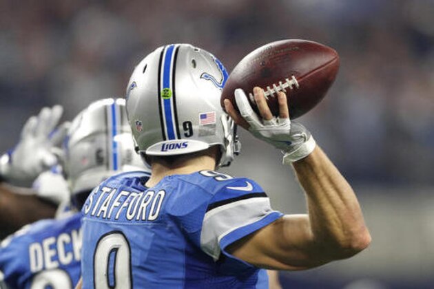 The throwing hand and glove of Detroit Lions' Matthew Stafford is highlighted as the throws a pass in the first half of an NFL football game against the Dallas Cowboys on Monday, Dec. 26, 2016, in Arlington, Texas. (AP Photo/Brandon Wade)