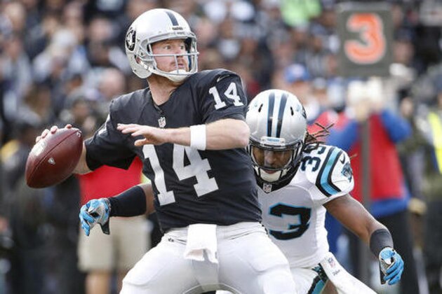 FILE - In this Nov. 27, 2016, file photo, Oakland Raiders quarterback Matt McGloin (14) drops back as Carolina Panthers free safety Tre Boston (33) applies pressure during the second half of an NFL football game in Oakland, Calif. After losing star quarterback Derek Carr to a broken leg, the Raiders now turn to McGloin with the AFC West title on the line in the season finale at Denver. (AP Photo/Tony Avelar, File)