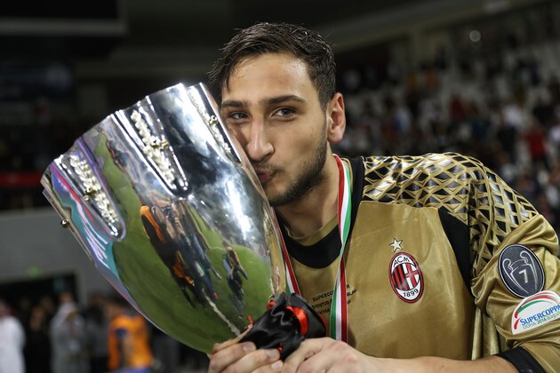 AC Milan's goalkeeper Gianluigi Donnarumma poses with the trophy after winning the Italian Super Cup final match between AC Milan and Juventus in Doha on December 23, 2016.
AC Milan beat Juventus to win the Italian Super Cup in a penalty shootout, the first trophy the Rossoneri have won since 2011.

 / AFP / KARIM JAAFAR        (Photo credit should read KARIM JAAFAR/AFP/Getty Images)