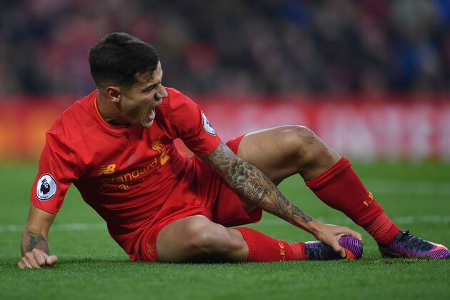 Liverpool's Brazilian midfielder Philippe Coutinho holds his foot as he lies on the pitch injured during the English Premier League football match between Liverpool and Sunderland at Anfield in Liverpool, north west England on November 26, 2016. / AFP / Paul ELLIS / RESTRICTED TO EDITORIAL USE. No use with unauthorized audio, video, data, fixture lists, club/league logos or 'live' services. Online in-match use limited to 75 images, no video emulation. No use in betting, games or single club/league/player publications.  /         (Photo credit should read PAUL ELLIS/AFP/Getty Images)