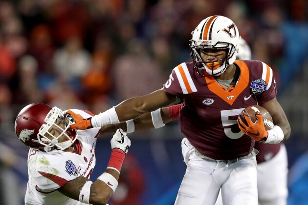 CHARLOTTE, NC - DECEMBER 29:  Santos Ramirez #9 of the Arkansas Razorbacks tries to stop Cam Phillips #5 of the Virginia Tech Hokies during the Belk Bowl at Bank of America Stadium on December 29, 2016 in Charlotte, North Carolina.  (Photo by Streeter Lecka/Getty Images)