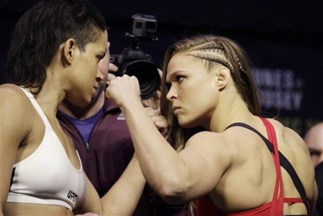 Ronda Rousey, right, and Amanda Nunes face off for photographers during an event for UFC 207, Thursday, Dec. 29, 2016, in Las Vegas. Rousey is scheduled to fight Nunes in a mixed martial arts women's bantamweight championship bout Saturday in Las Vegas. (AP Photo/John Locher)