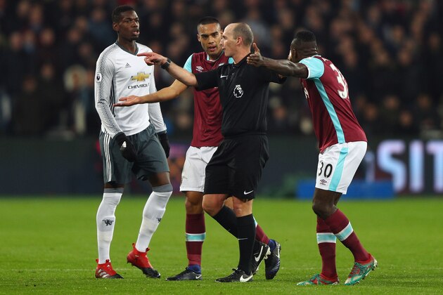 STRATFORD, ENGLAND - JANUARY 02: Referee Mike Dean is confronted by Winston Reid and Michail Antonio of West Ham United as Paul Pogba of Manchester United looks on during the Premier League match between West Ham United and Manchester United at London Stadium on January 2, 2017 in Stratford, England.  (Photo by Ian Walton/Getty Images)