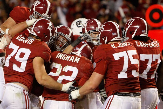 TUSCALOOSA - OCTOBER 17:  Alabama Crimson Tide teammates, including offensive lineman Drew Davis, offensive lineman Barrett Jones #75 and offensive lineman James Carpenter #77, swarm running back Mark Ingram #22 after his fourth quarter, game clinching touchdown during the game against the South Carolina Gamecocks at Bryant-Denny Stadium on October 17, 2009 in Tuscaloosa, Alabama. The Crimson Tide beat the Gamecocks 20-6.  (Photo by Mike Zarrilli/Getty Images)