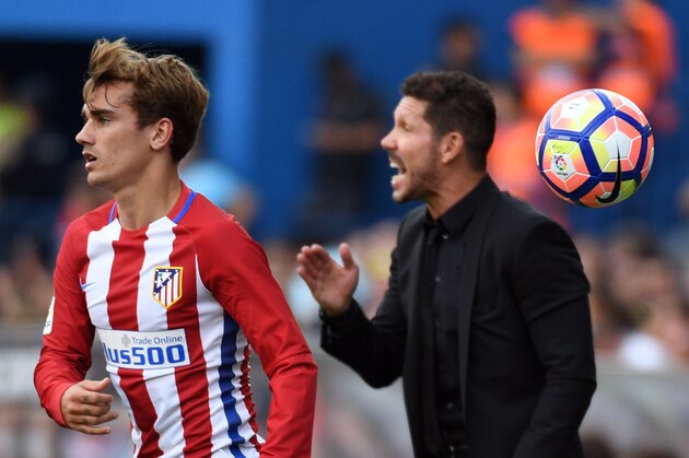 Atletico Madrid's French forward Antoine Griezmann (L) throws the ball beside Atletico Madrid's Argentinian coach Diego Simeone during the Spanish league football match Club Atletico de Madrid vs RC Deportivo de la Coruna at the Vicente Calderon stadium in Madrid on September 25, 2016. / AFP / GERARD JULIEN        (Photo credit should read GERARD JULIEN/AFP/Getty Images)