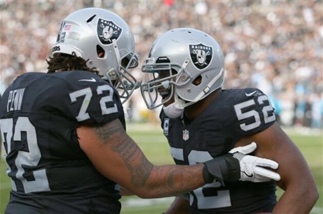 Oakland Raiders linebacker Khalil Mack (52) receives congratulations from Donald Penn in action against the Carolina Panthers during an NFL football game Sunday, Nov. 27, 2016, in Oakland, CA. The Raiders won 35-32. (Daniel Gluskoter/AP Images for Panini)