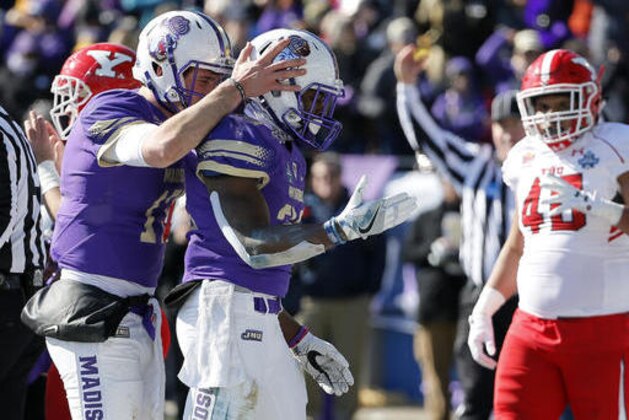 James Madison's Bryan Schor, left, celebrates a touchdown scored on a run by running back Khalid Abdullah, center, as Youngstown State's Jaylin Kelly, right, watches in the first half of the FCS championship NCAA college football game, Saturday, Jan. 7, 2017, in Frisco, Texas. (AP Photo/Tony Gutierrez)