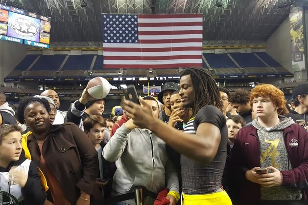 Najee Harris, the nation's top-ranked player, takes pictures with fans at the U.S. Army All-American Bowl. Harris said he is still undecided regarding his college plans. He's expected to enroll Monday. Harris is committed to Alabama but has been questioned about a potential flip to Michigan.