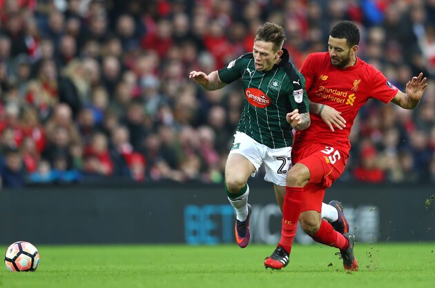 LIVERPOOL, ENGLAND - JANUARY 08: Craig Tanner of Plymouth Argyle (L) is fouled by Kevin Stewart of Liverpool (R) during The Emirates FA Cup Third Round match between Liverpool and Plymouth Argyle at Anfield on January 8, 2017 in Liverpool, England.  (Photo by Michael Steele/Getty Images)