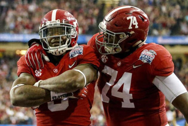 Alabama running back Bo Scarbrough (9) celebrates with Alabama offensive lineman Cam Robinson (74) after scoring a touchdown against Washington during the first half of the Peach Bowl NCAA college football game, Saturday, Dec. 31, 2016, in Atlanta. (AP Photo/Butch Dill)