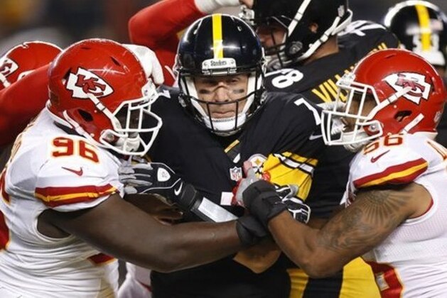 El quarterback de los Steelers de Pittsburgh Ben Roethlisberger (7) es detenido por el defensa de los Chiefs de Kansas City Jaye Howard (96) y Derrick Johnson (56), en la primera mitad de su juego de NFL en Pittsburgh, el domingo 2 de octubre de 2016. (AP Foto/Jared Wickerham)