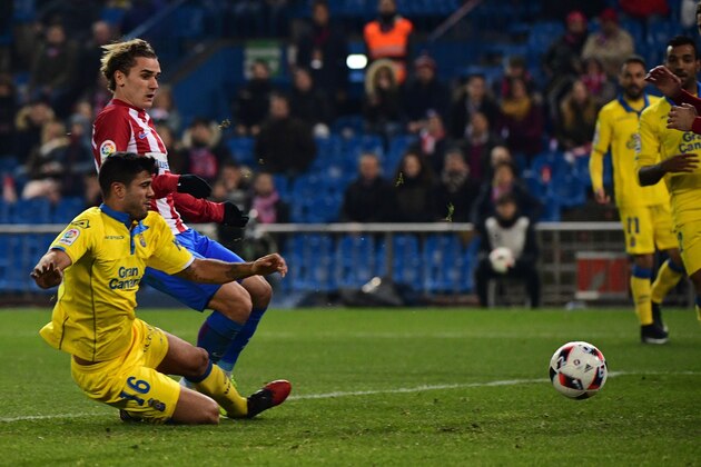 Atletico Madrid's French forward Antoine Griezmann (Up) kicks the ball to score beside Las Palmas' defender Aythami Artiles during the Spanish Copa del Rey (King's Cup) round of 16 second leg football match Club Atletico de Madrid vs UD Las Palmas at the Vicente Calderon stadium in Madrid on January 10, 2017. / AFP / PIERRE-PHILIPPE MARCOU        (Photo credit should read PIERRE-PHILIPPE MARCOU/AFP/Getty Images)