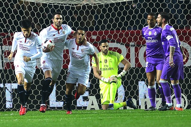 Sevilla's players (L) celebrate after Real Madrid's Brazilian defender Danilo (2ndR) scored an own goal during the Spanish Copa del Rey (King's Cup) round of 16 second leg football match Sevilla FC vs Real Madrid CF at the Ramon Sanchez Pizjuan stadium in Sevilla on January 12, 2017. / AFP / CRISTINA QUICLER        (Photo credit should read CRISTINA QUICLER/AFP/Getty Images)